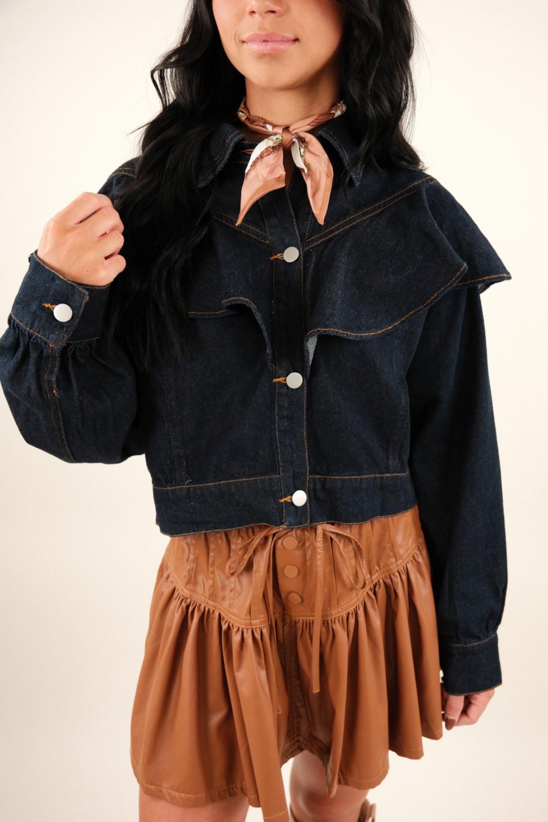 Close-up of Rodeo Ruffle Denim Jacket highlighting dark wash denim texture, ruffle detail and structured cowgirl style collar.