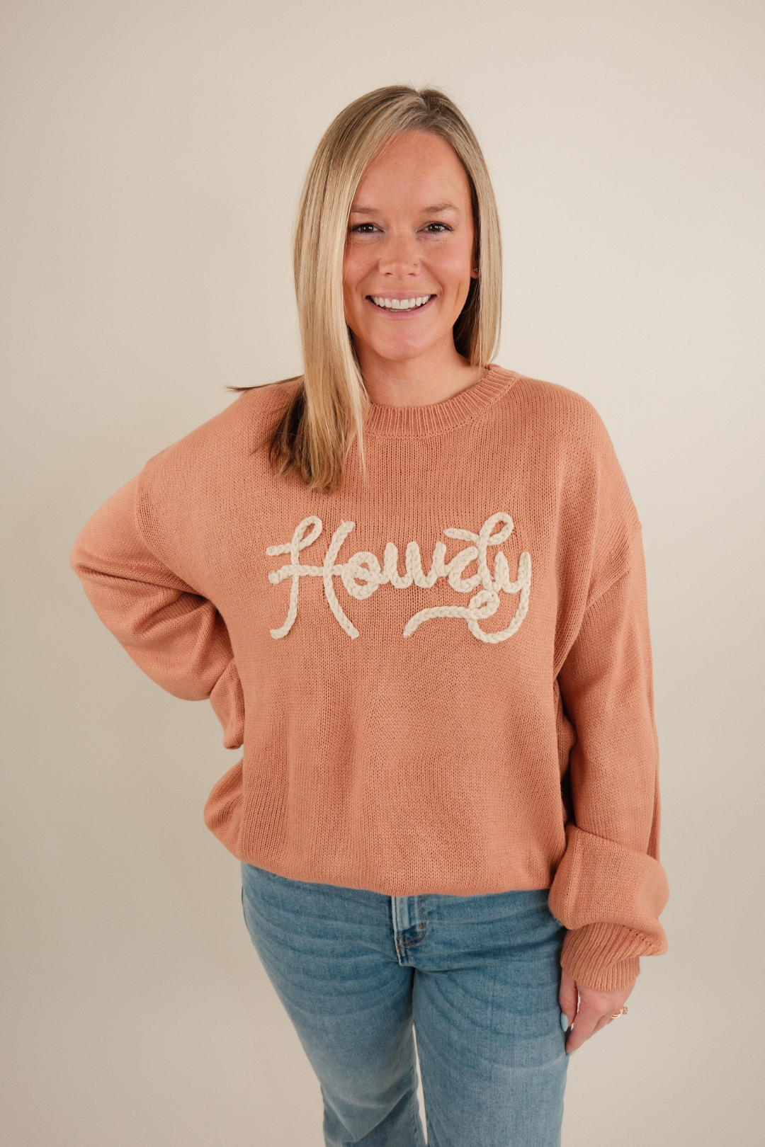 Front view of Rope & Howdy Sweater in warm clay knit with ‘Howdy’ stitched in rope-inspired letters, relaxed fit.
