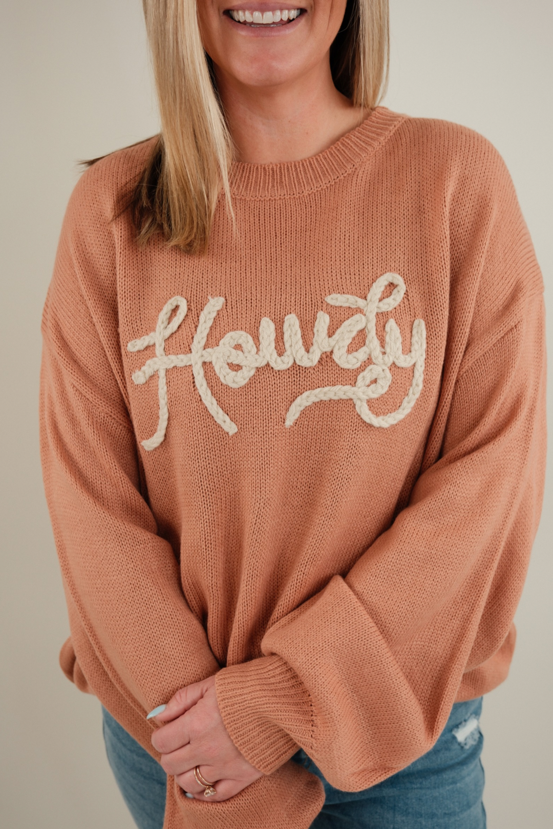 Close-up of Rope & Howdy Sweater showing rope-stitched western ‘Howdy’ lettering on clay knit fabric, cowgirl sweater detail.