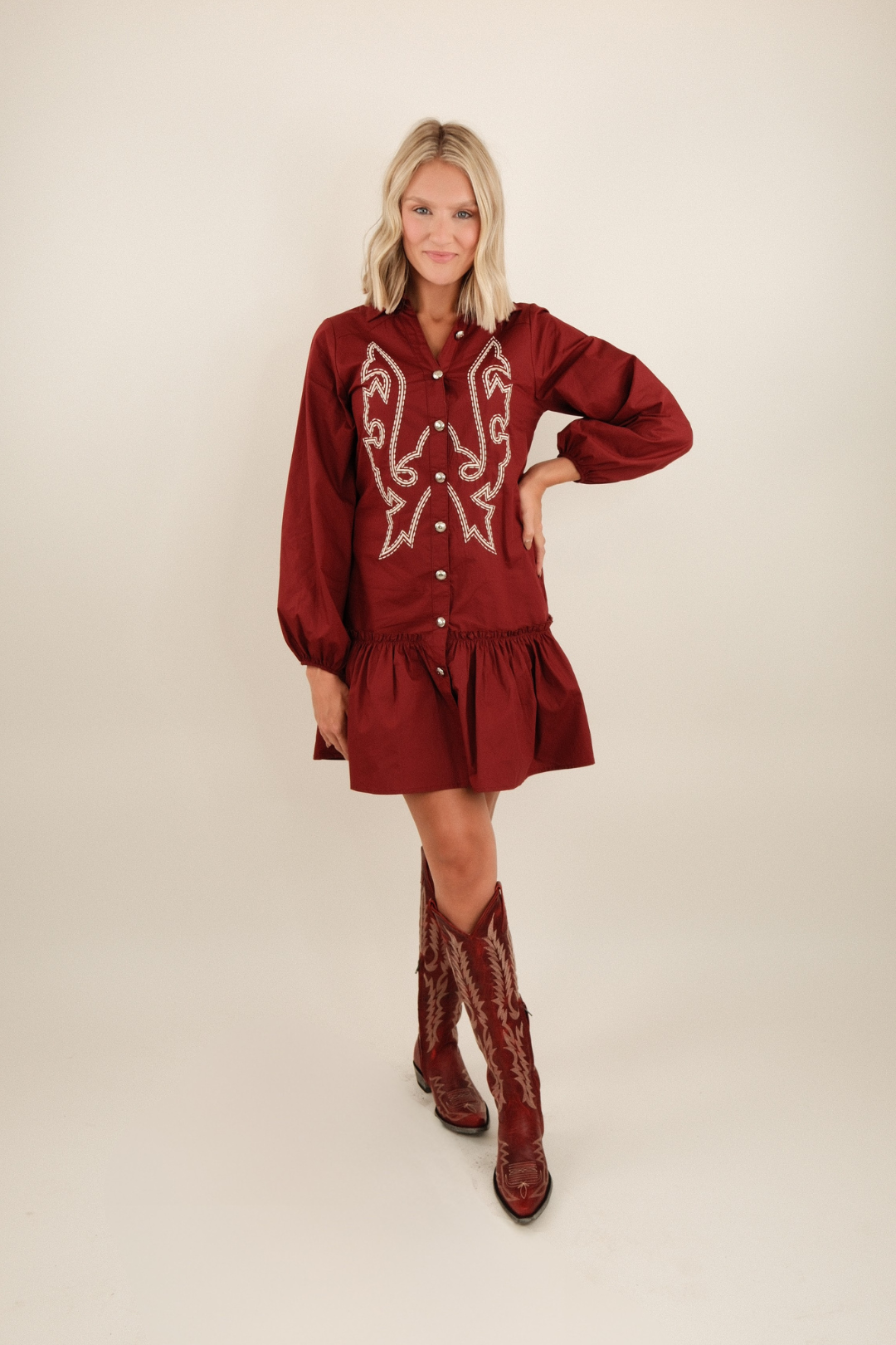 Lightweight western button-down burgundy dress with collar, concho buttons, boot stitch embroidery, and peplum ruffle hem.