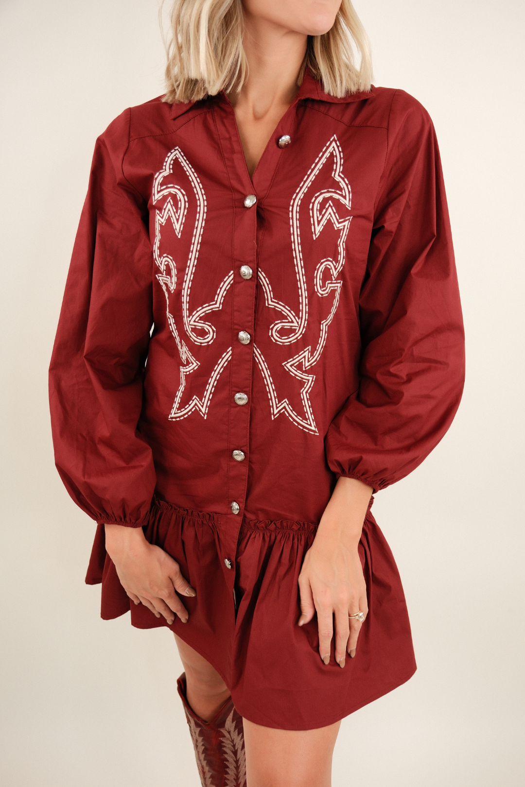 Front view of Saddle & Stitch Dress in burgundy, button-down western style with collar, boot stitch embroidery and ruffle hem.