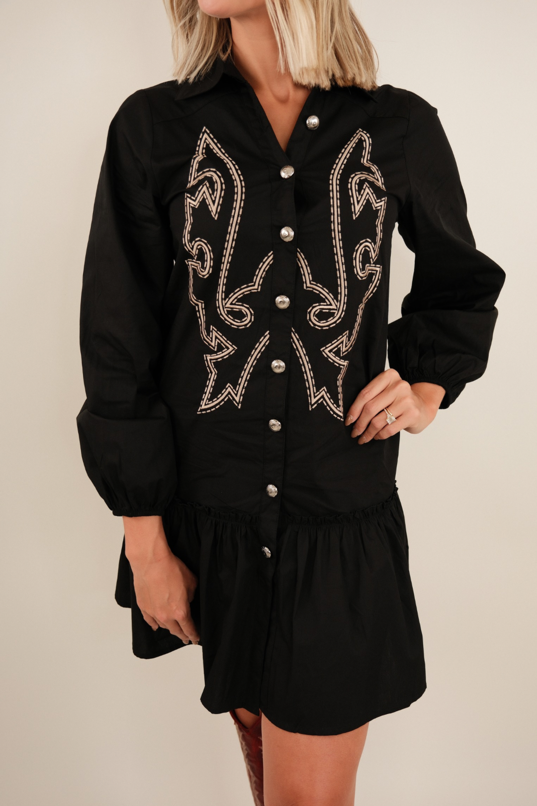 Front view of Saddle & Stitch Dress in black, button-down western style with collar, boot stitch embroidery and ruffle hem.