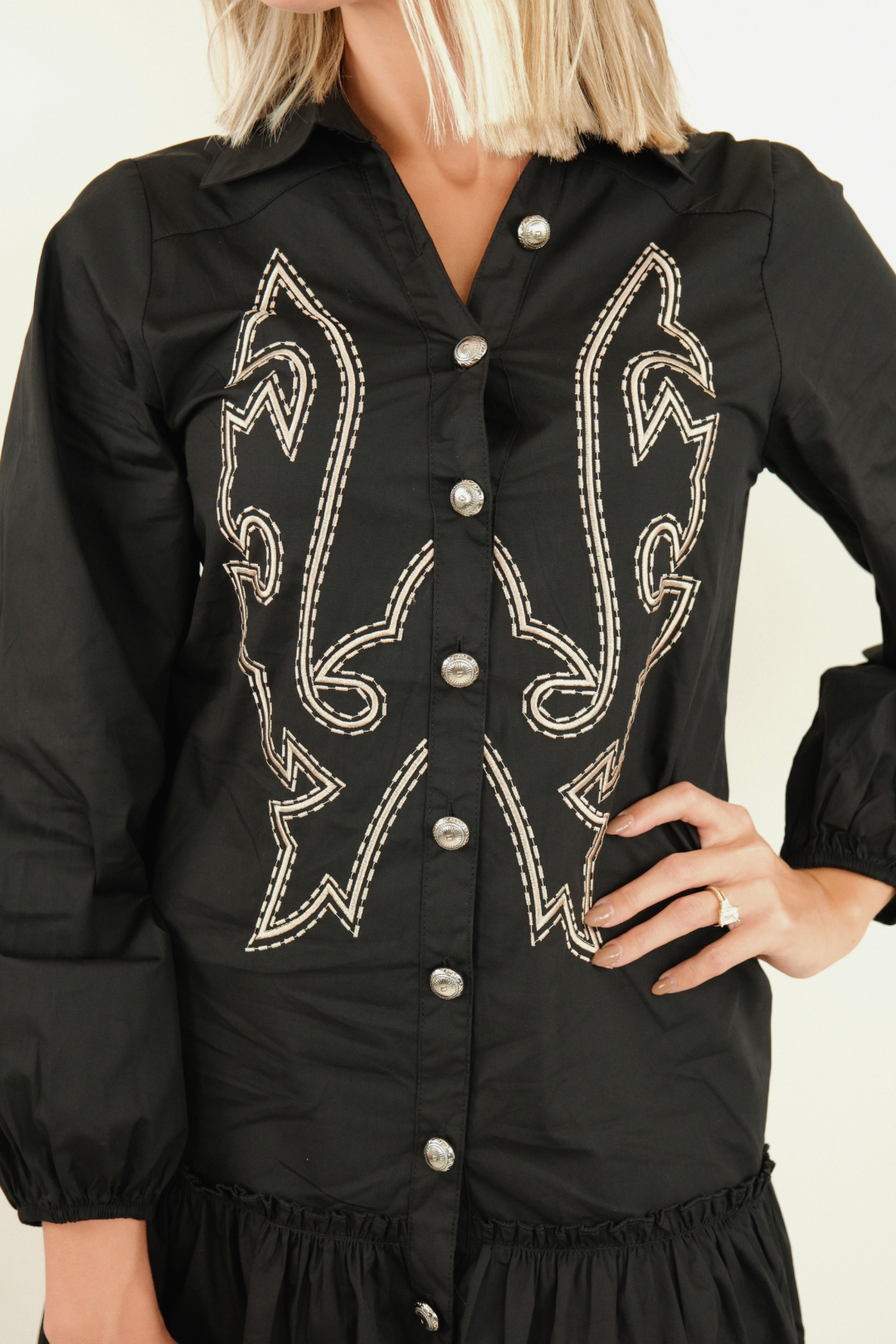 Close-up of Saddle & Stitch Dress in black highlighting concho buttons, boot stitch embroidery and soft fabric detail.