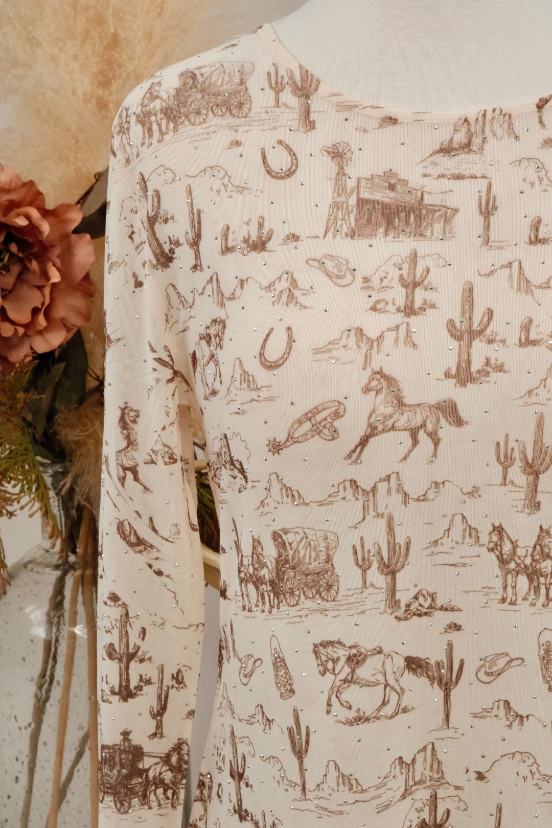 Long-sleeve mesh shirt with a desert-themed pattern featuring cacti, horses, and other elements.