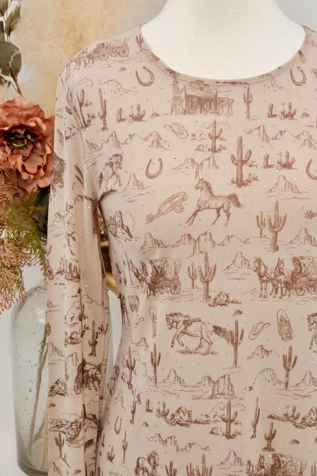 Long-sleeve mesh shirt with desert-themed pattern on a mannequin against a neutral background.