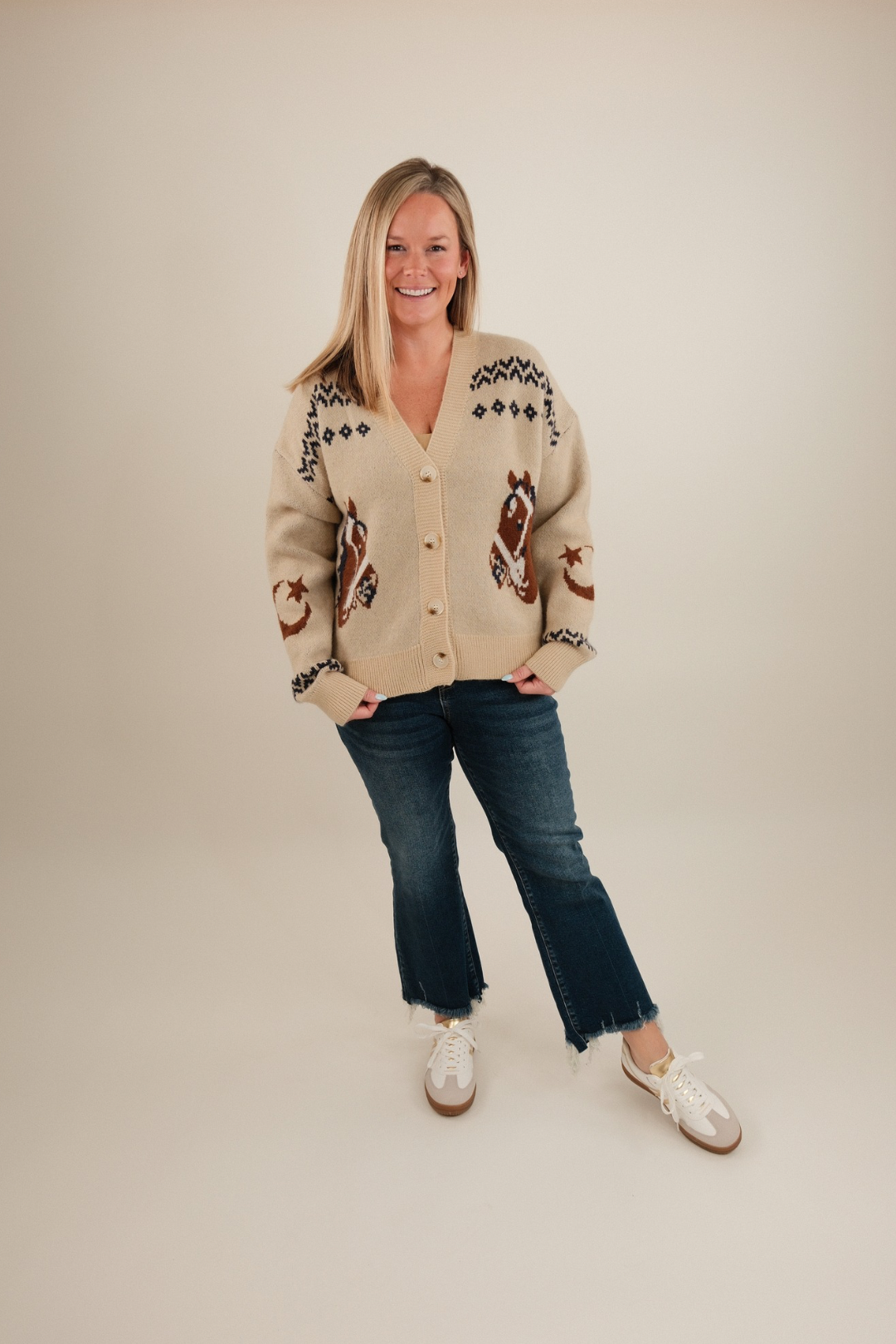 Full body shot of model in women’s Starlight Mustang Cardigan, beige knit cowgirl sweater styled with denim.