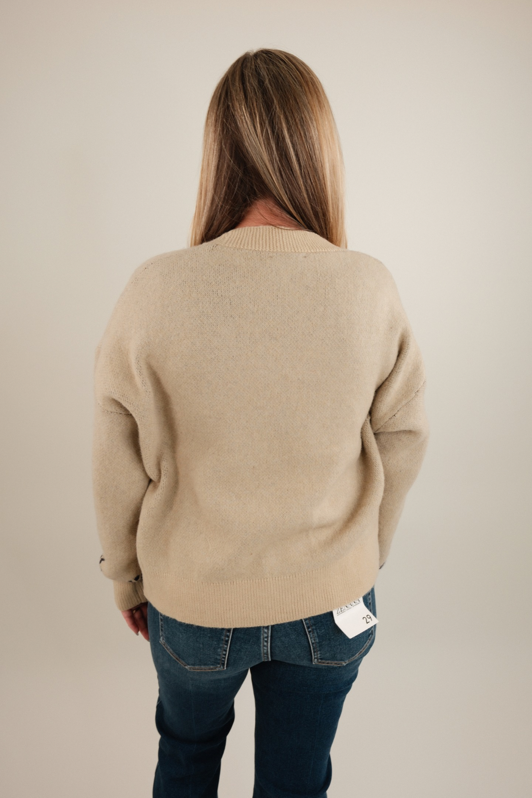 Back view of Starlight Mustang Cardigan, women’s beige knit cowgirl cardigan with bold galloping horse design.