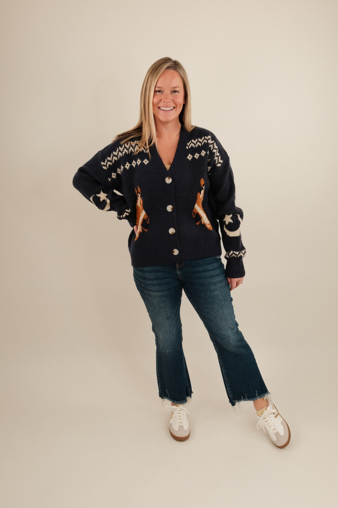 Full body shot of model in women’s Starlight Mustang Cardigan, navy knit cowgirl sweater styled with denim.