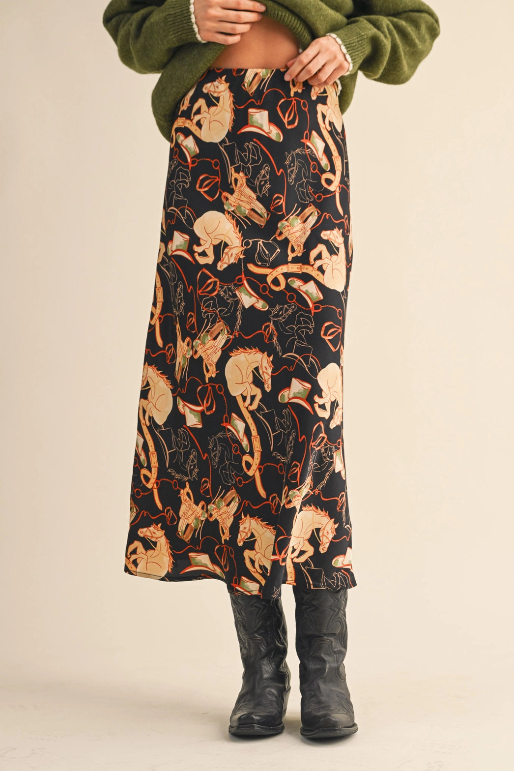 Model wearing Stirrup Stories Satin Midi Skirt styled with boots, western equestrian print slip skirt with satin drape.