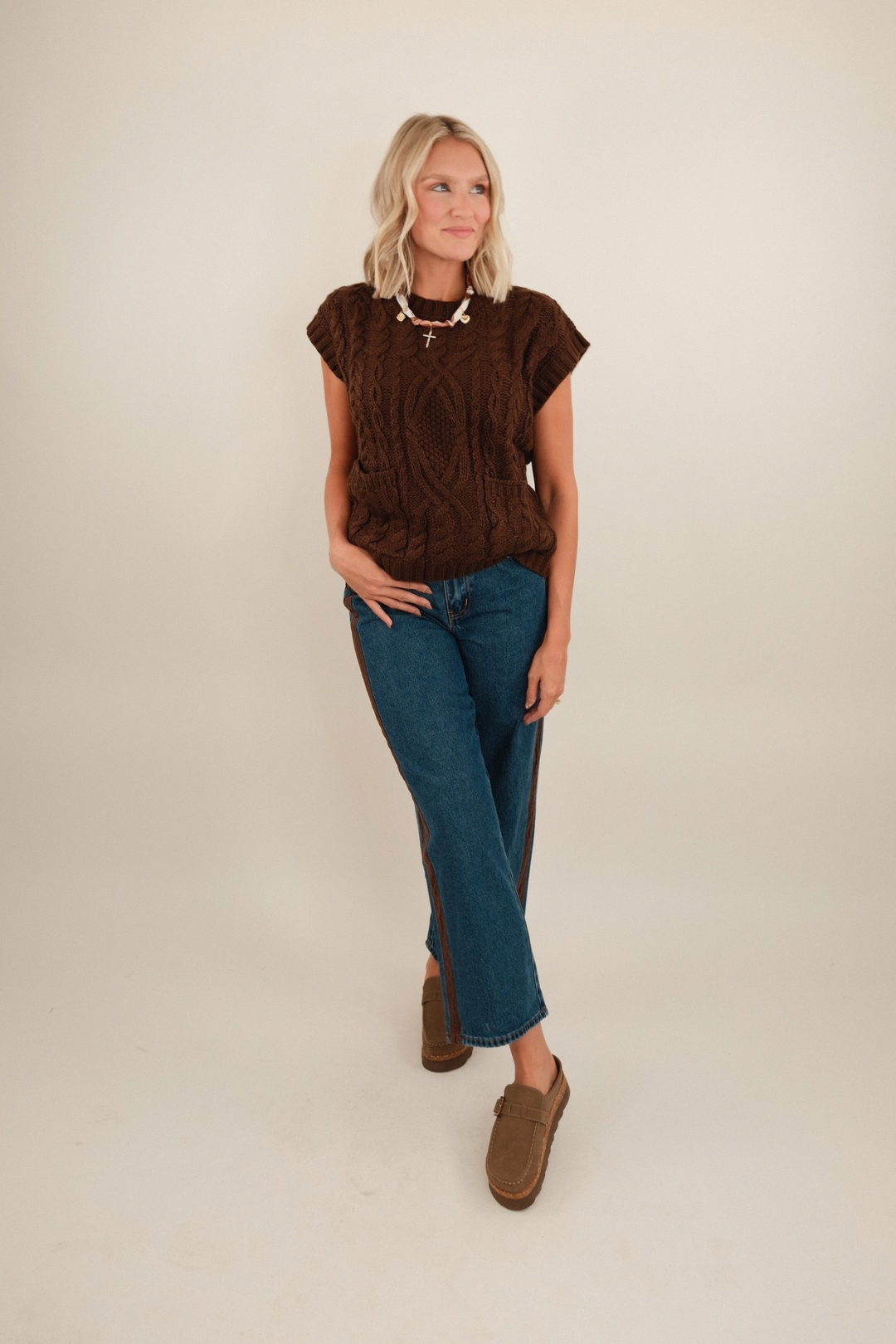 Full body shot of model wearing Sundance straight leg denim jeans in mid-wash blue with clogs.