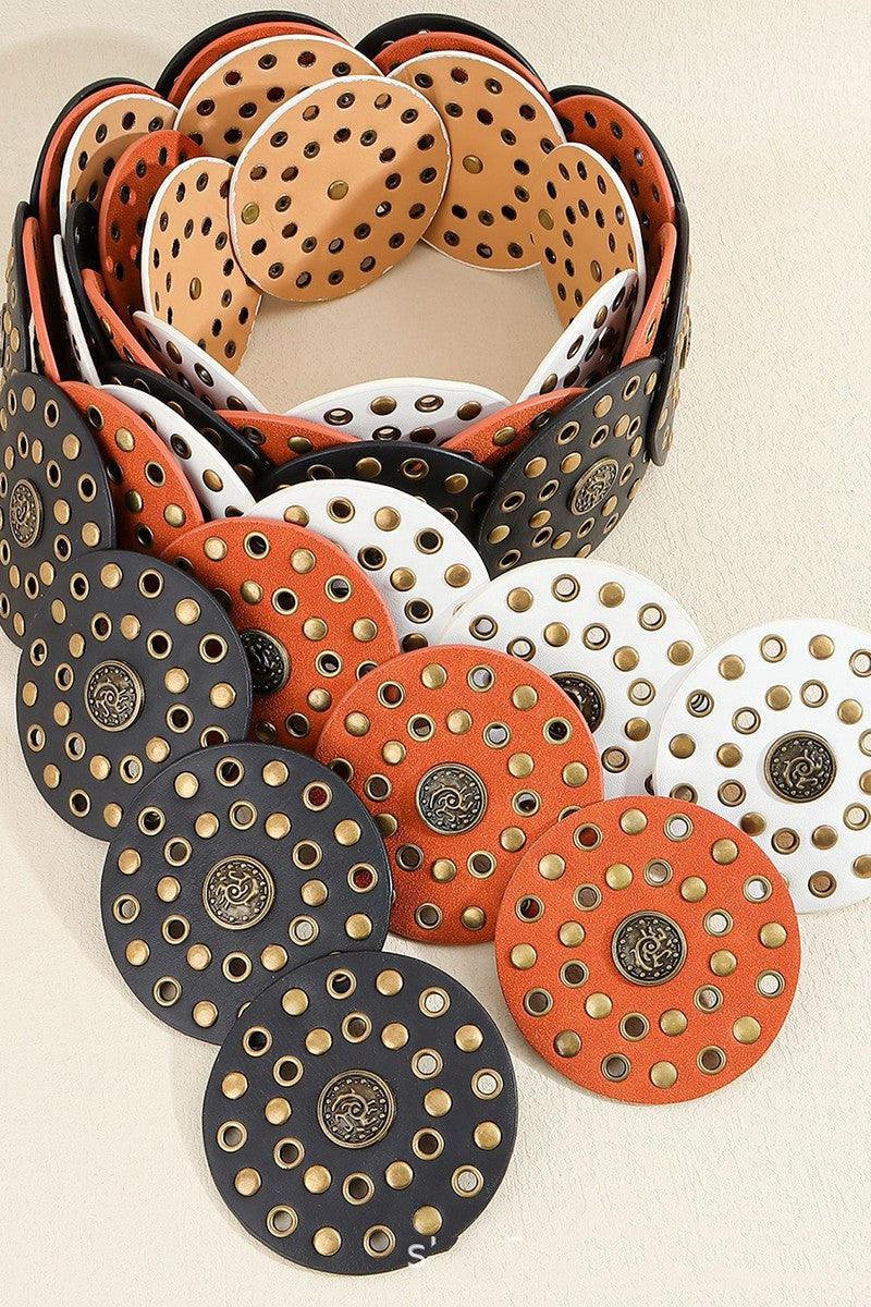 Set of belts with circular designs and central studs on a beige background