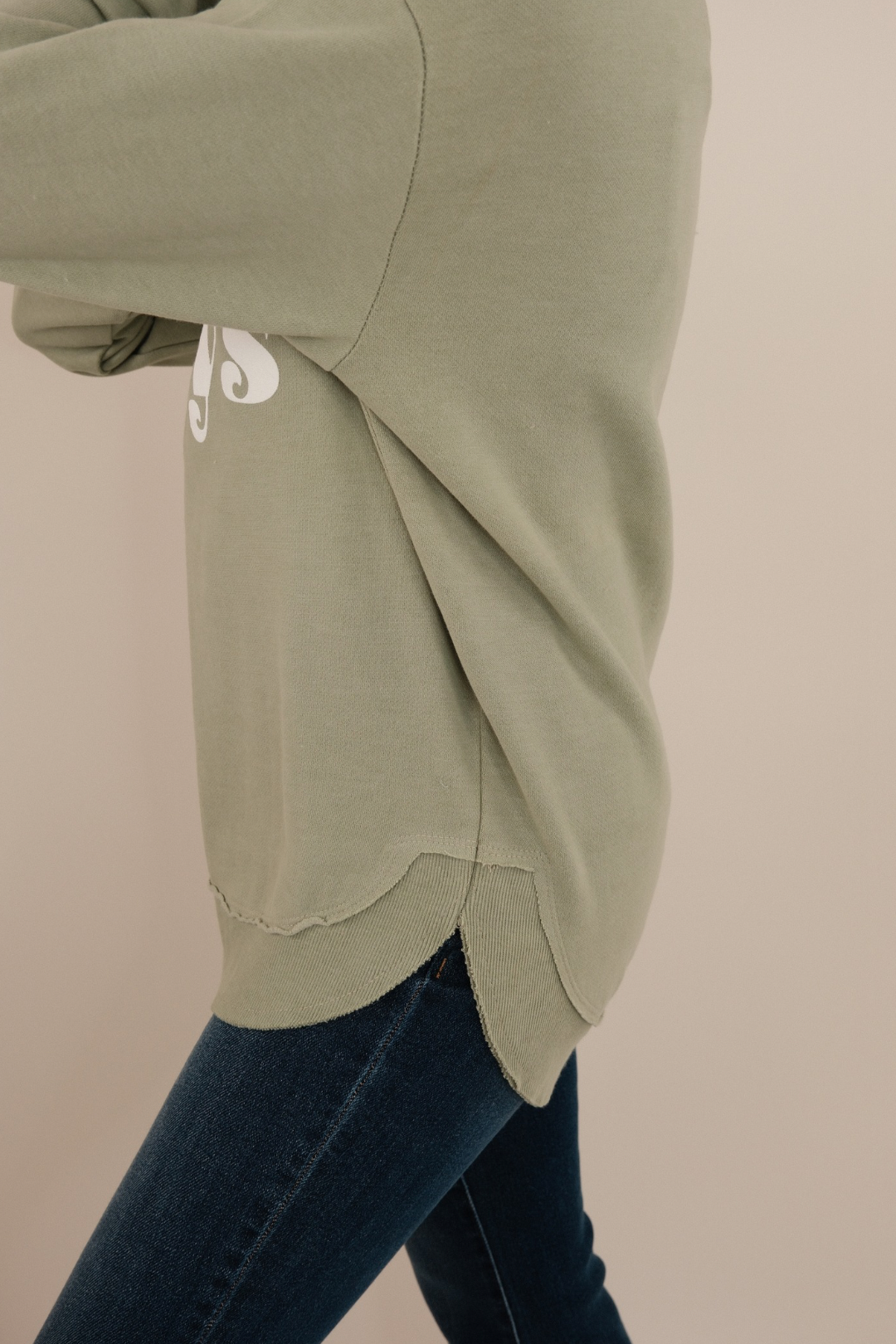 Side profile of This Mama Prays Poncho Fleece showing draped sage knit fabric, cozy relaxed fit and rounded hemline.