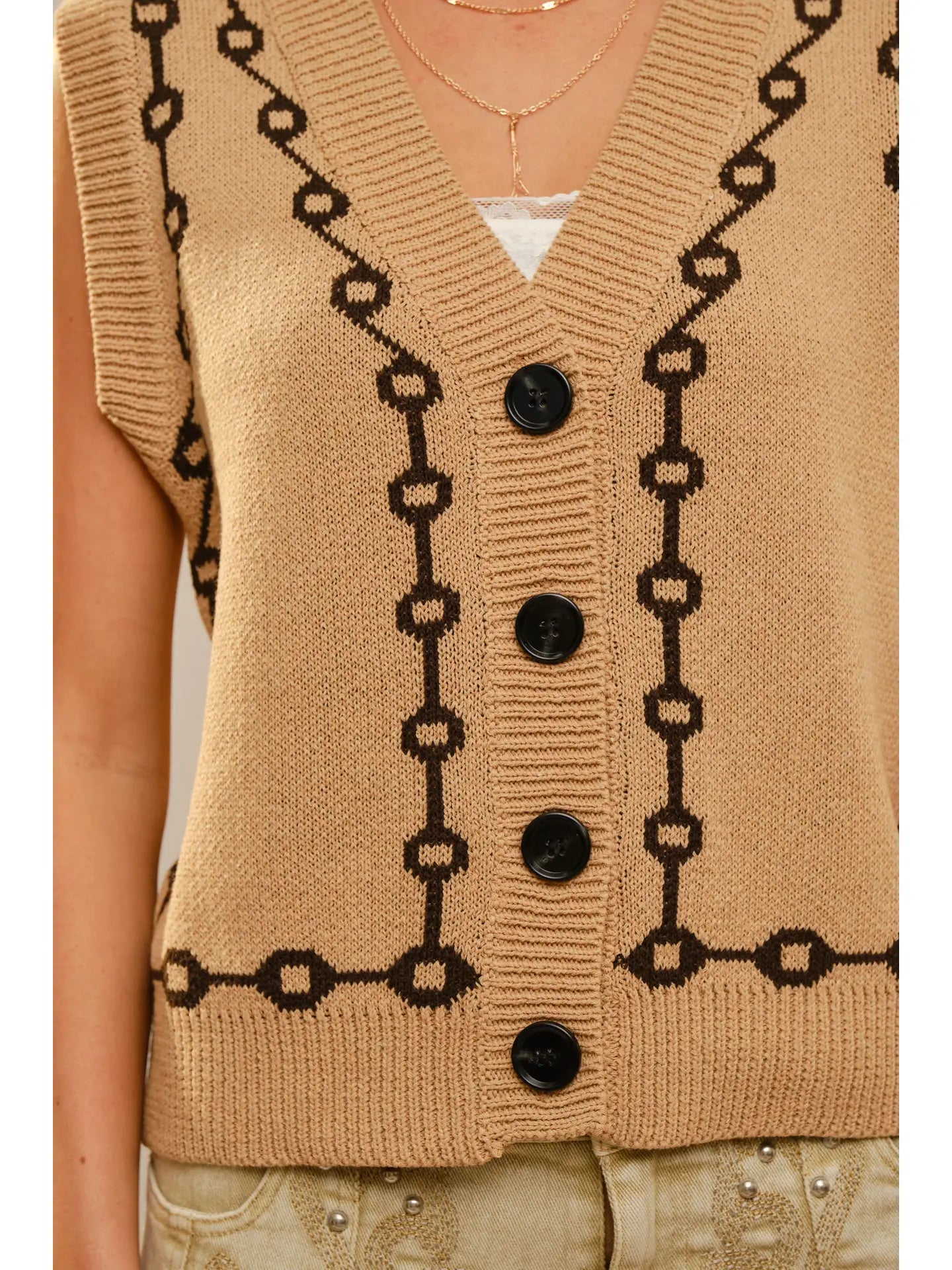 Beige knitted vest with brown bit chain style pattern and buttons on a white background