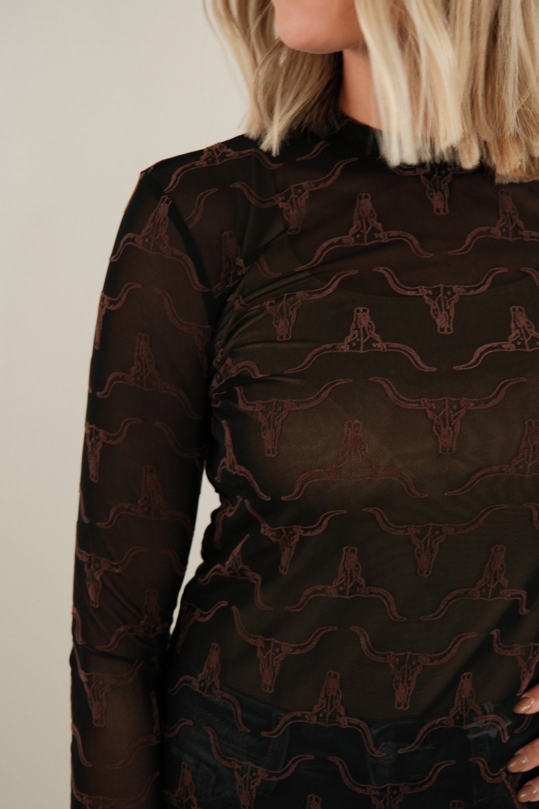 Side profile of women’s Velvet Longhorn Mesh Top, black mesh with raised brown velvet longhorn design for cowgirl chic style.