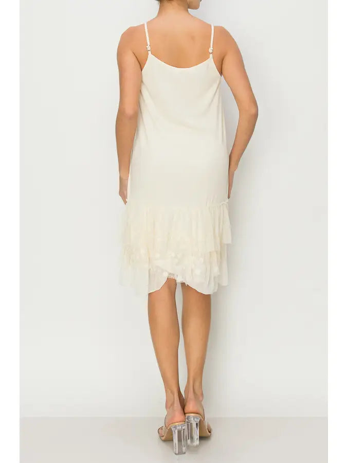 Cream slip dress worn by a person on a white background