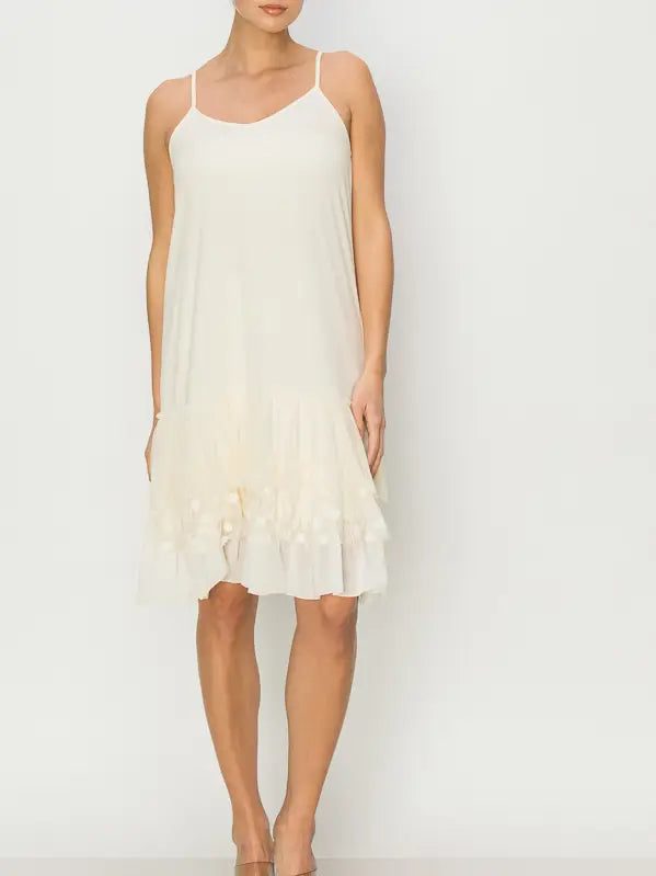 Cream slip dress worn by a model on a plain background