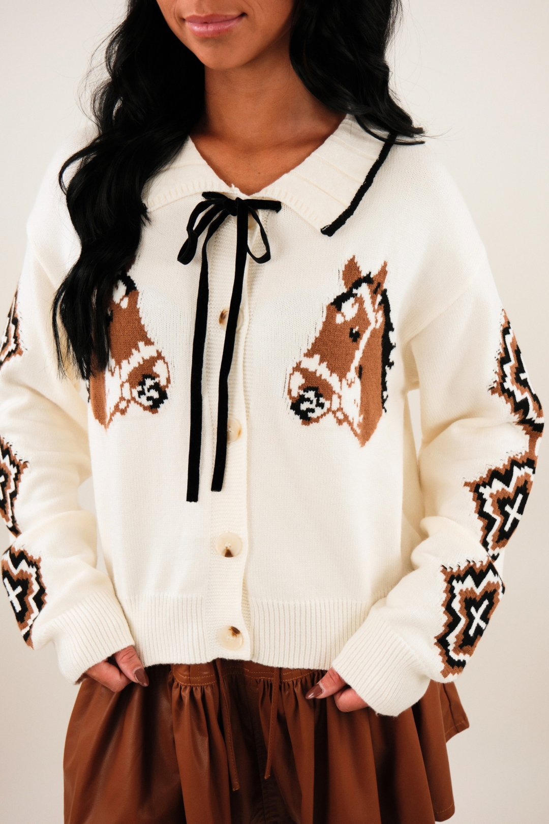 Close-up of Western Belle Cardigan highlighting horse head motif, Aztec sleeve knit and button detail.