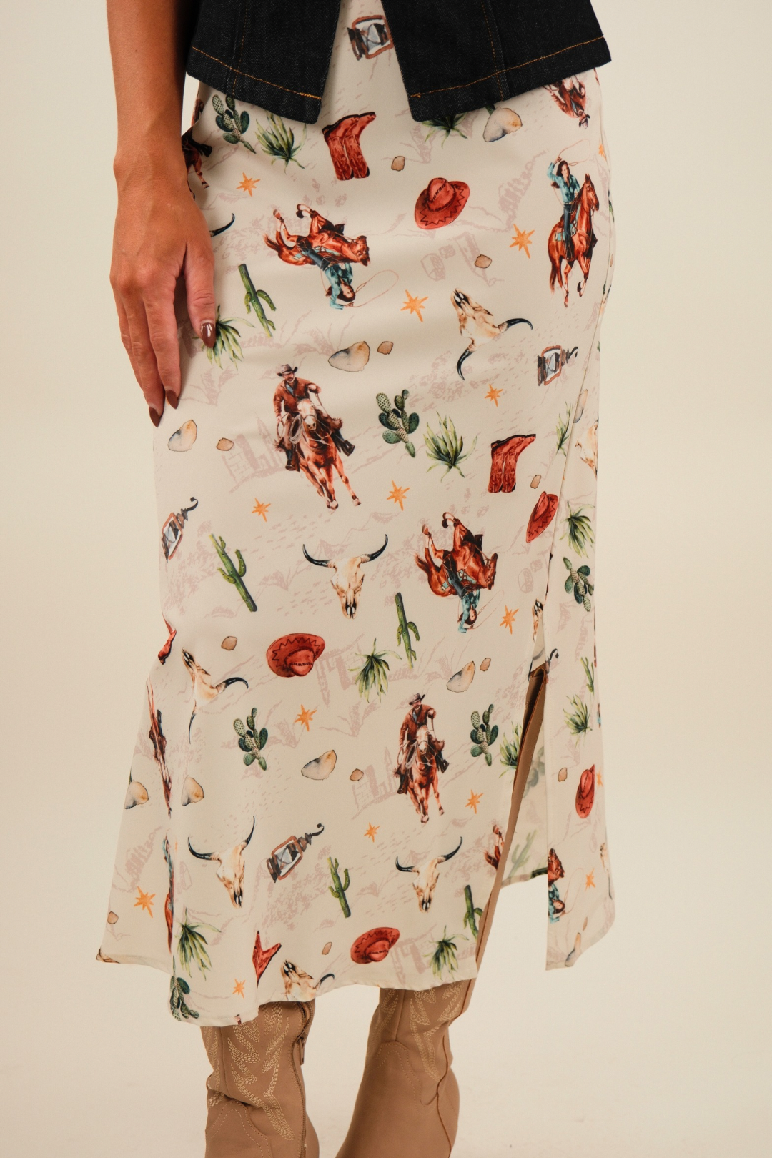Close-up of Western Muse Skirt highlighting cream fabric with playful western motifs — horses, cacti, skulls and cowboy hats.