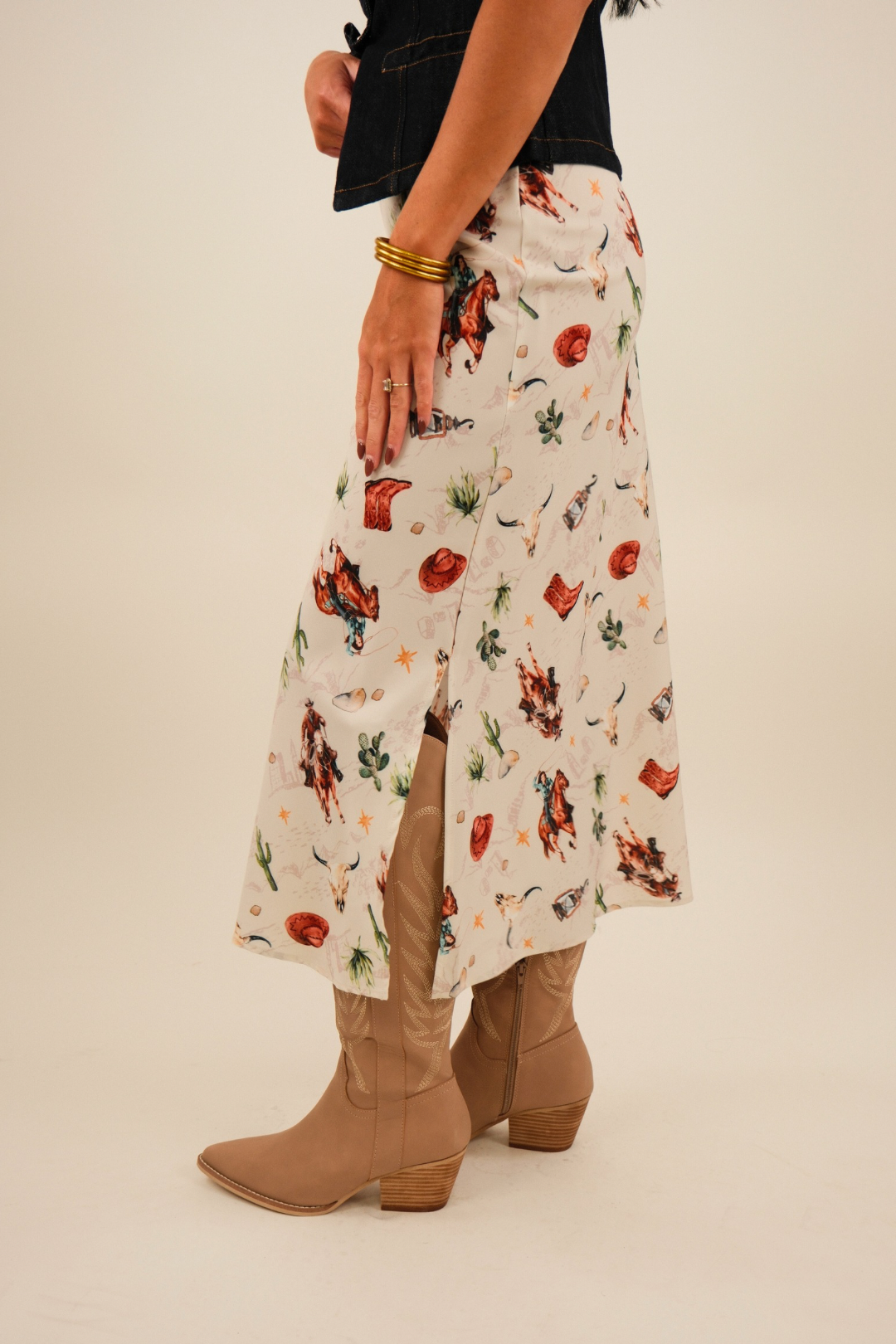 Side profile of Western Muse Skirt showing cream base, straight silhouette with western motif print and small side slit detail.