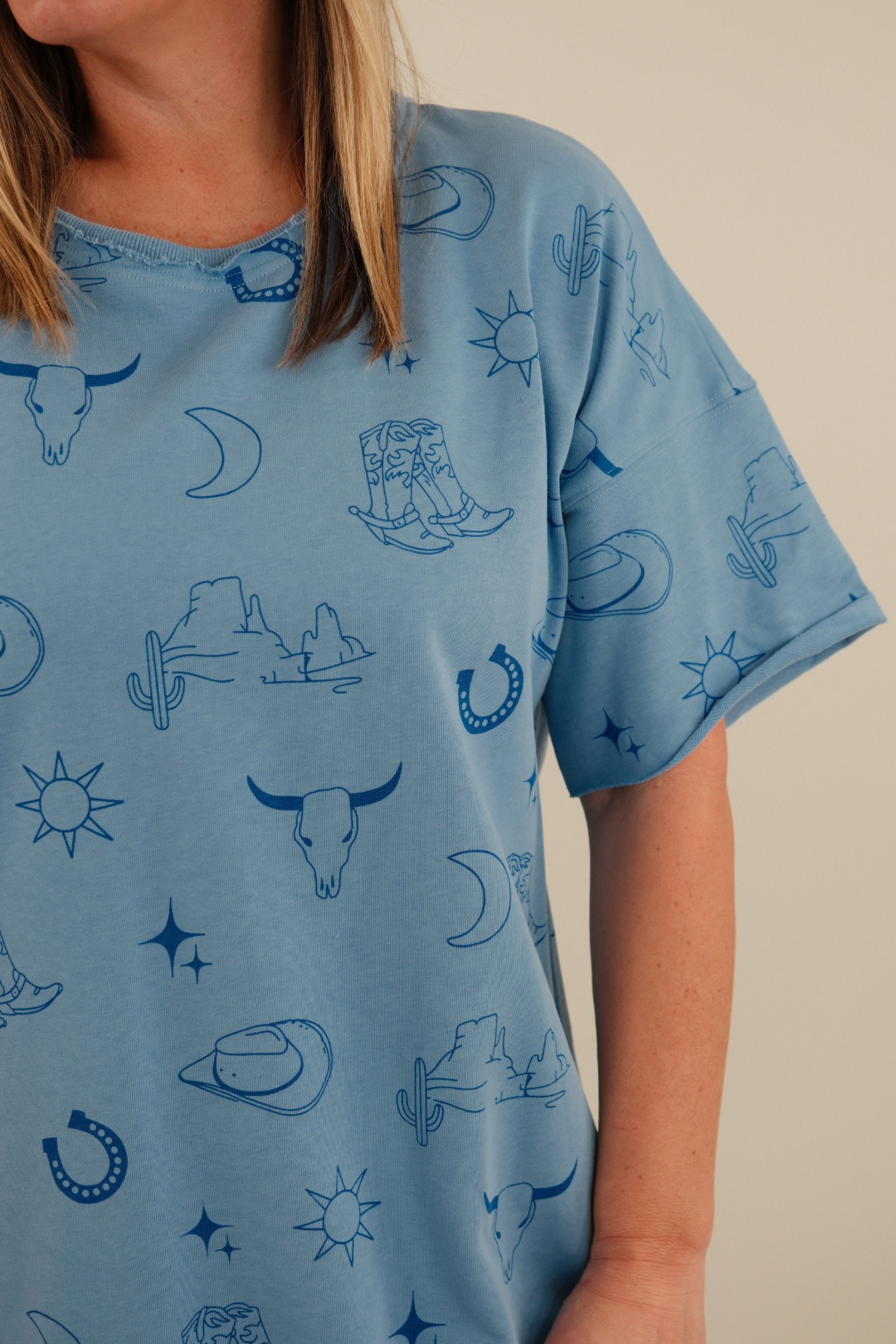 Side profile of women’s Western Skies Tee Dress, light blue western t-shirt dress with casual drape and straight silhouette.