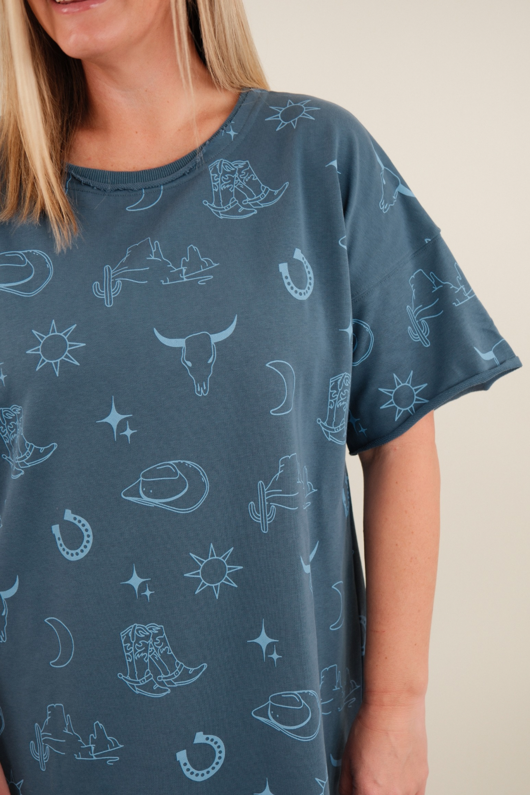 Side profile of women’s Western Skies Tee Dress, dusty blue western t-shirt dress with casual drape and straight silhouette.