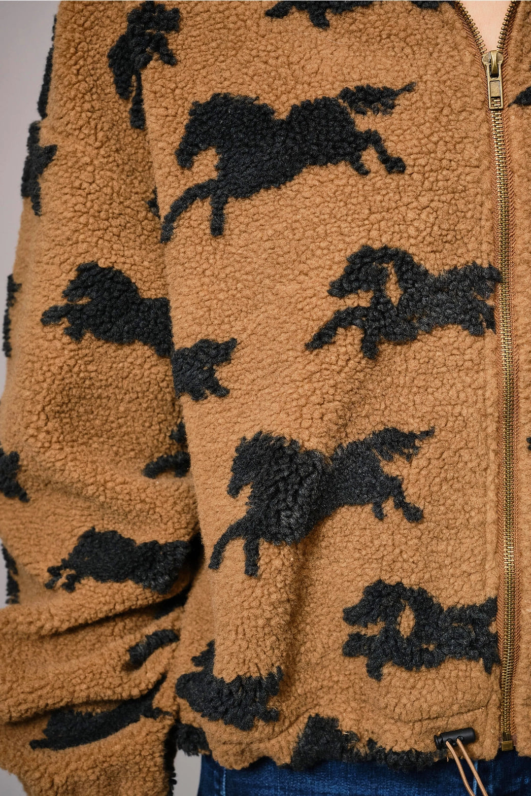 Brown fleece jacket with black horse patterns