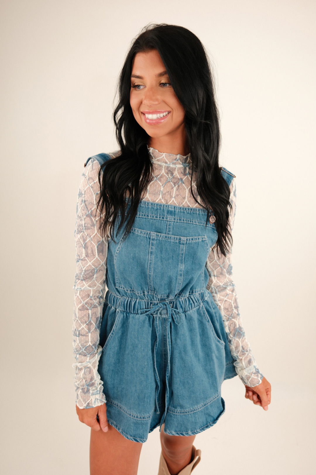 A model wearing a sheer blue and cream mesh top with western motifs—white or turquoise cacti and horses—long sleeves and crew neckline