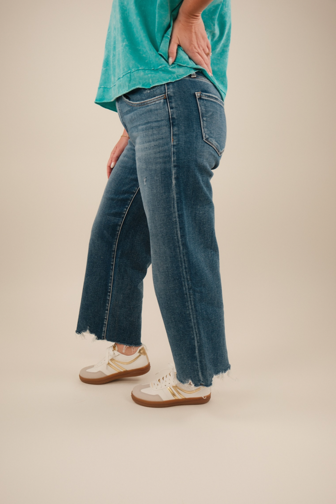 Side profile of cropped flare jeans highlighting relaxed fit through thigh and angled hemline.