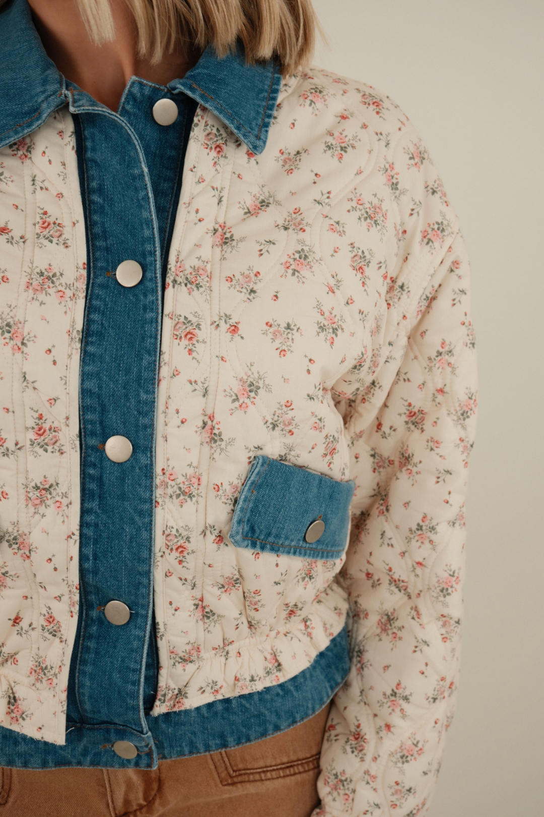 Medium wash Wildflower Quilted Denim Jacket with delicate floral quilting, denim ruffles at collar and cuffs, feminine western prairie style.