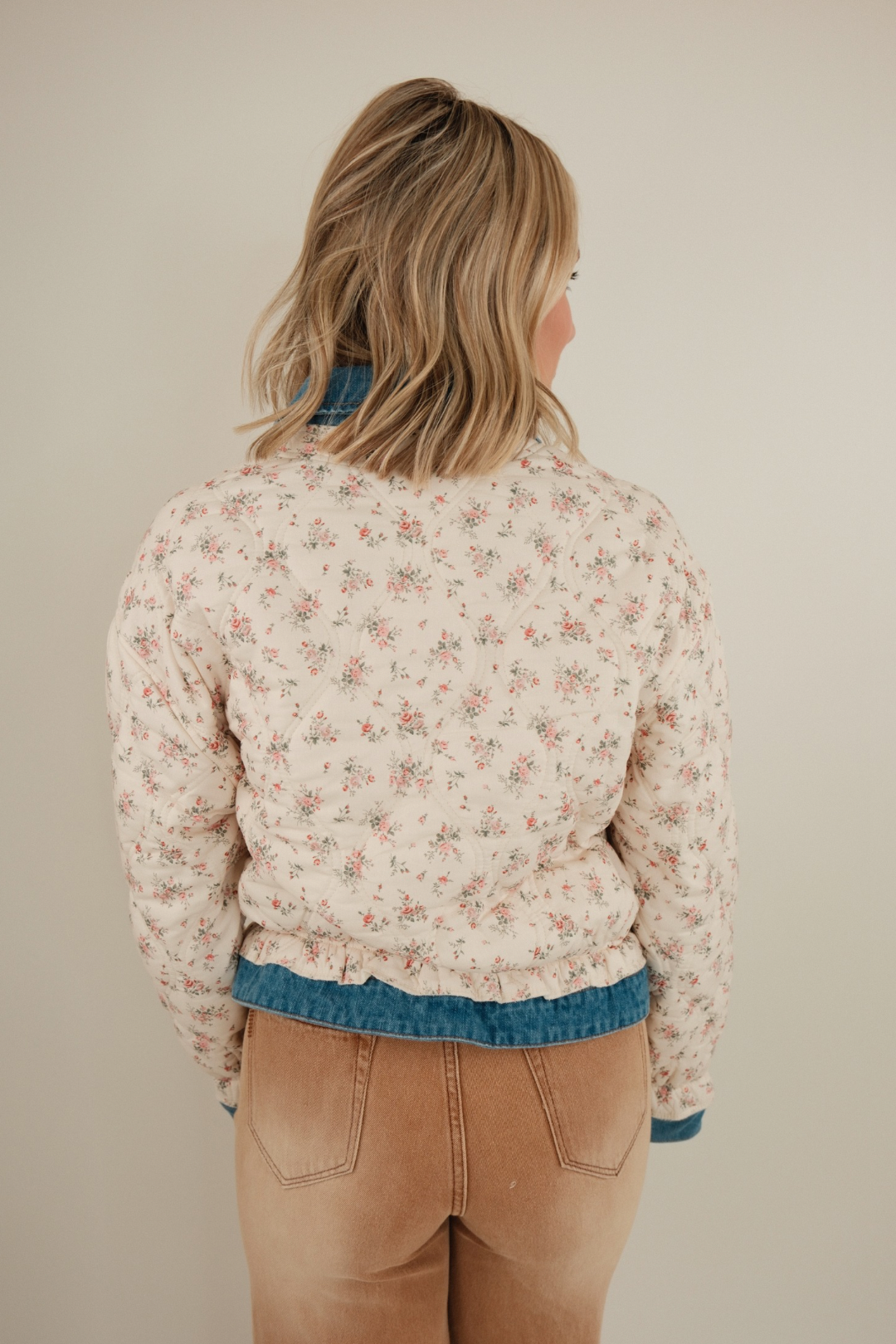 Back view of Wildflower Quilted Denim Jacket featuring medium wash denim, floral quilting and playful ruffle western accents.