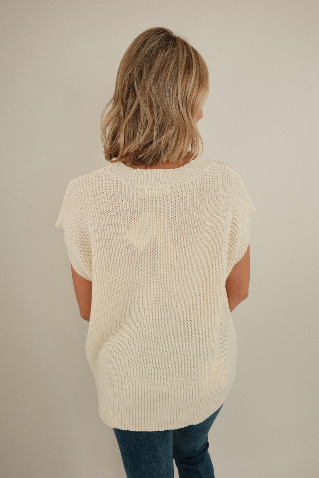 Back view of Wrangler’s Charm Sweater in cream, chunky sleeveless knit with ribbed texture and clean western silhouette.