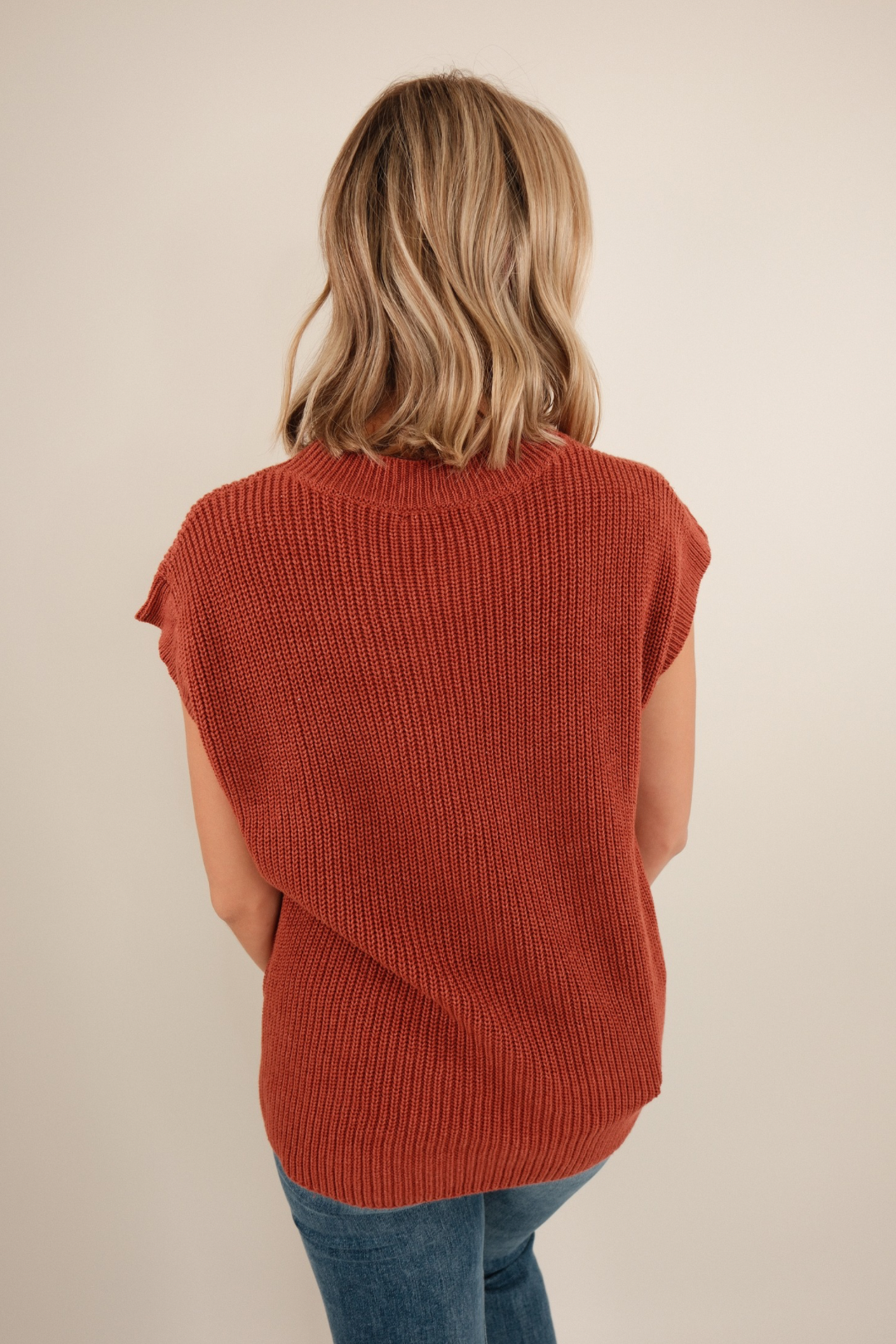 Back view of Wrangler’s Charm Sweater in brick, chunky sleeveless knit with ribbed texture and clean western silhouette.